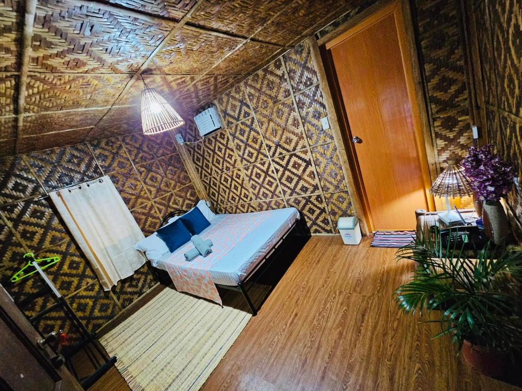 une chambre avec un lit, une table et une lampe dans l'établissement Ezekiel's Native Inn, à Panglao