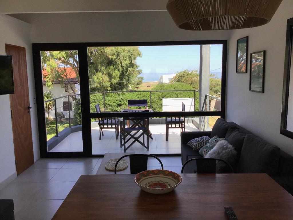 a living room with a table and a large glass door at Mar del Plata Acantilados vista al Mar in Mar del Plata