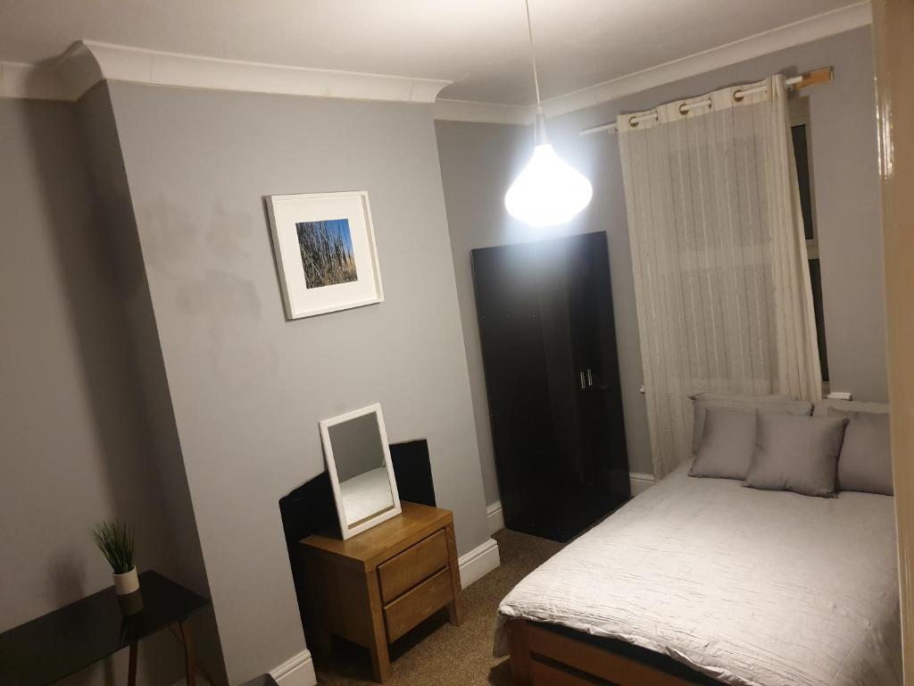 a bedroom with a bed and a mirror on a night stand at Derby rooms by Peartree in Derby