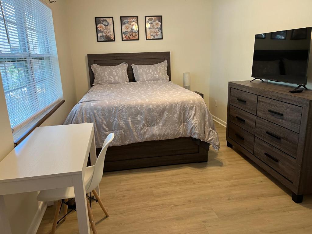 a bedroom with a bed and a desk and a television at ZenHomes in Brandon near Tampa Valrico Seffner in Brandon