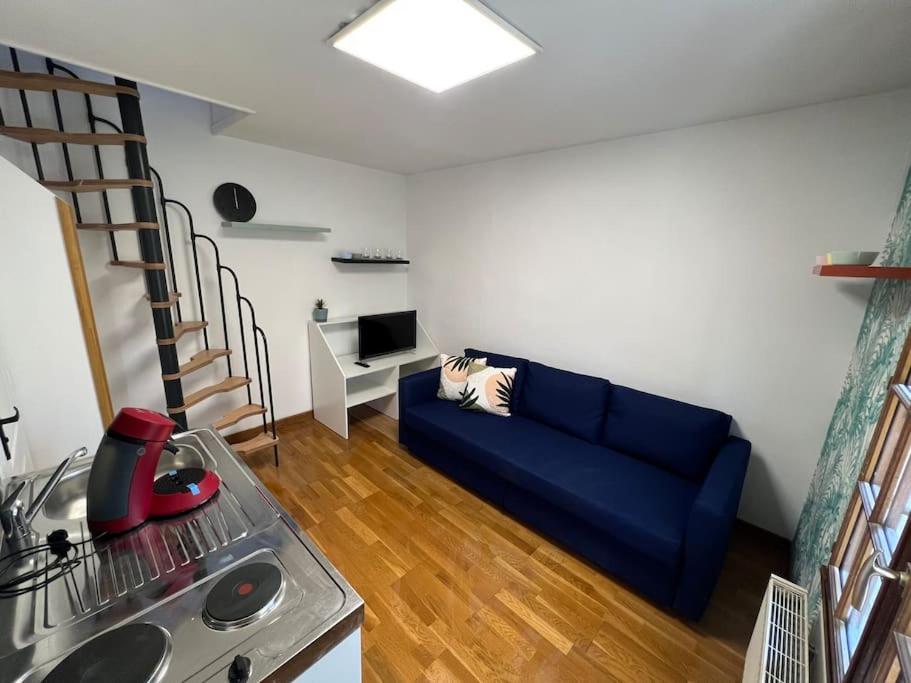 uma sala de estar com um sofá azul e uma cozinha em My casa 2 em Choisy-le-Roi