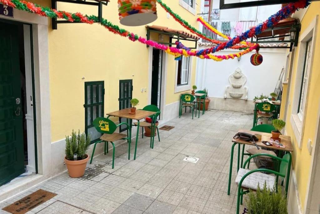 een patio met tafels en stoelen in een gebouw bij Mouraria Lisbon Soul Apartments T2 - 5pax in Lissabon