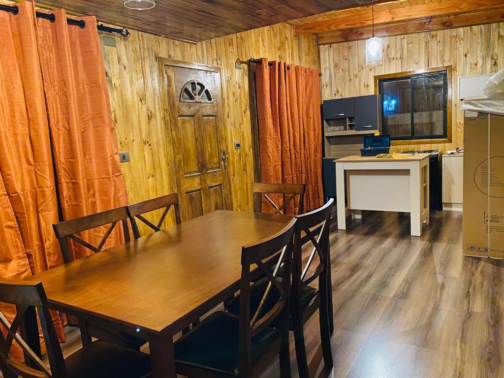 uma sala de jantar com uma mesa e uma cozinha em Cabañas EMC em Los Vilos