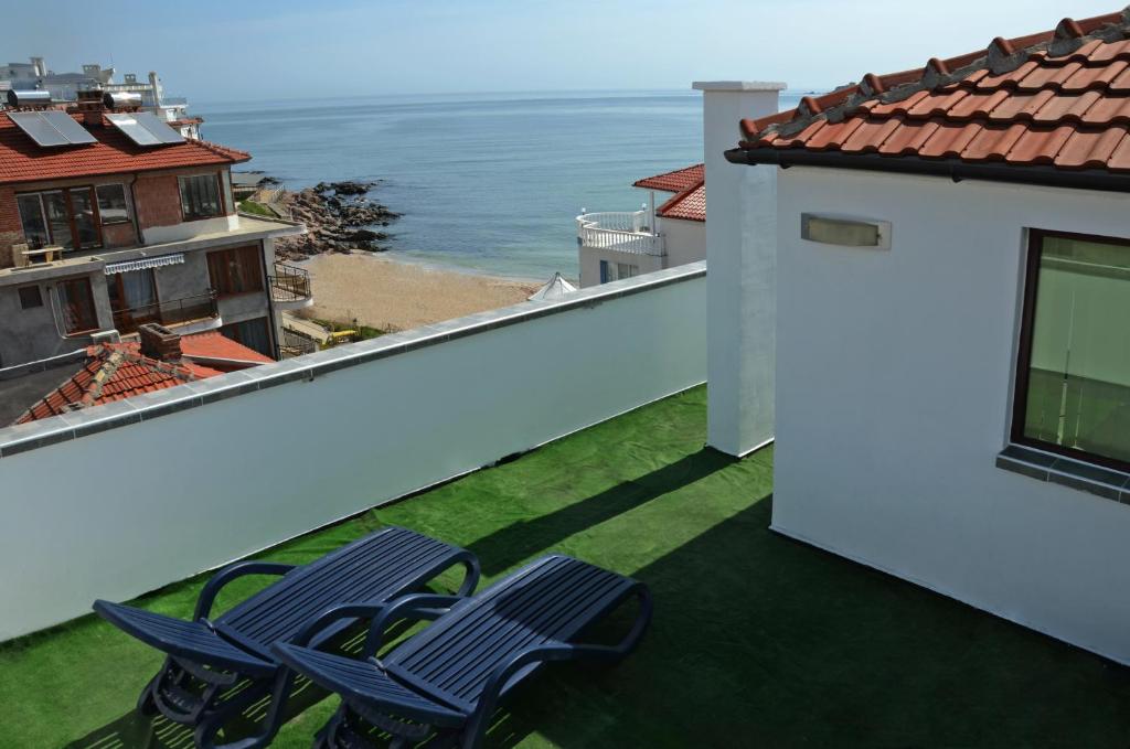 two chairs on a balcony with a view of the ocean at Kani Studios in Sozopol