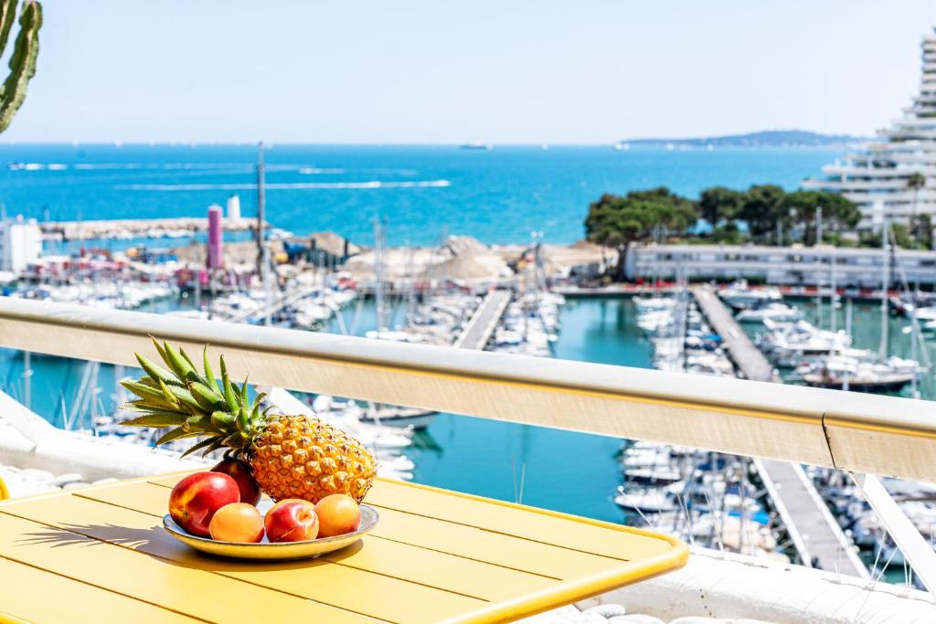 - un bol de fruits sur une table sur un balcon avec un port de plaisance dans l'établissement Grand 4 pièces 6 personnes fabuleuse vue mer clim garage, à Villeneuve-Loubet