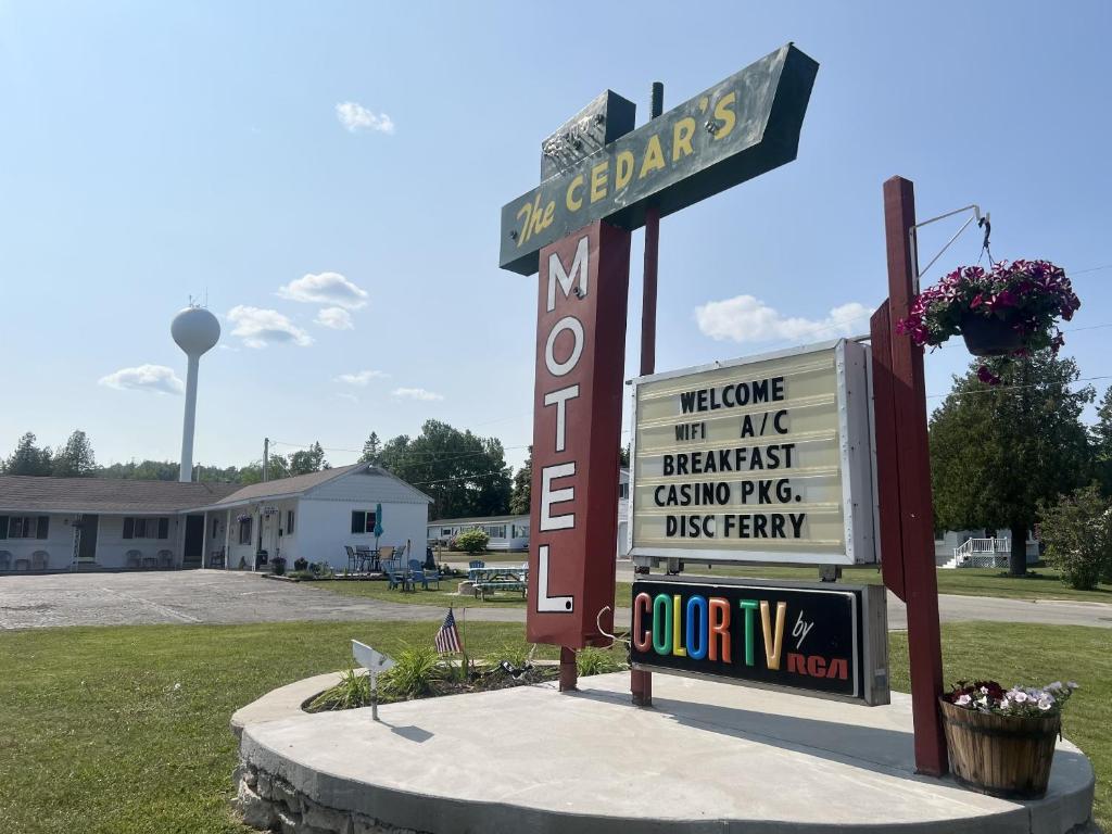 a sign for a motel in front of a building at Cedars Motel in Saint Ignace