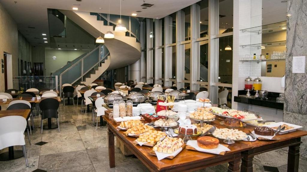 uma longa mesa com comida num restaurante em Promoção - Flat em Brasília em Brasília