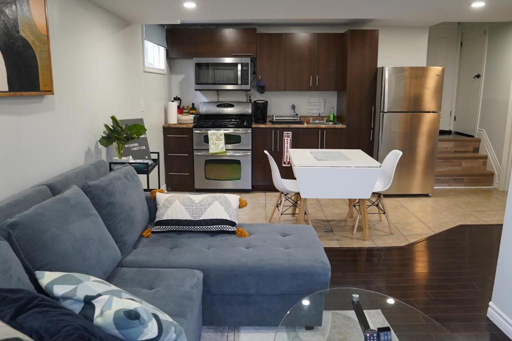 un soggiorno con divano blu e una cucina di Patio privé, hébergement équipé et spacieux. a Hamilton