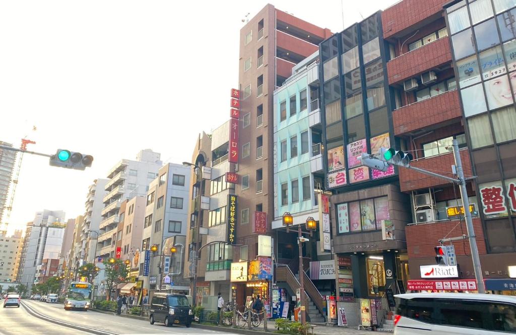 東京にあるTabist ホテルオーロラ 池袋の高層ビルと信号が並ぶ賑やかな街道