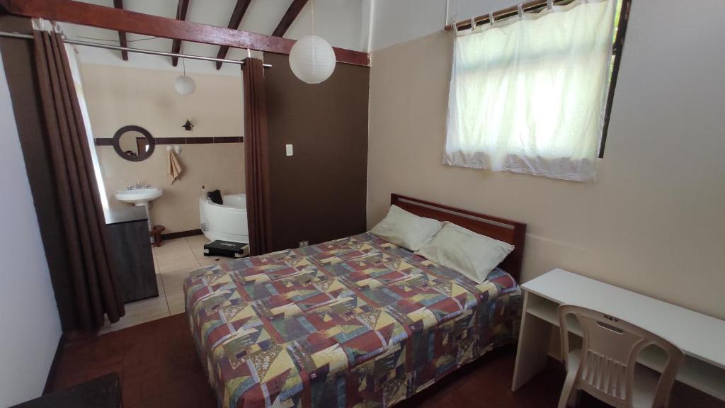 1 dormitorio con cama, mesa y lavamanos en BINNAH GUEST ROOM, en Moyobamba