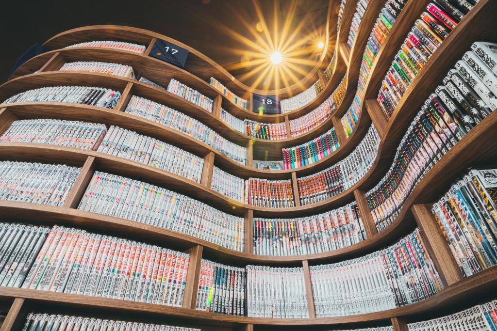 a library with rows of books on the ceilings at Quintessa Hotel Kokura Comic & Books in Kitakyushu