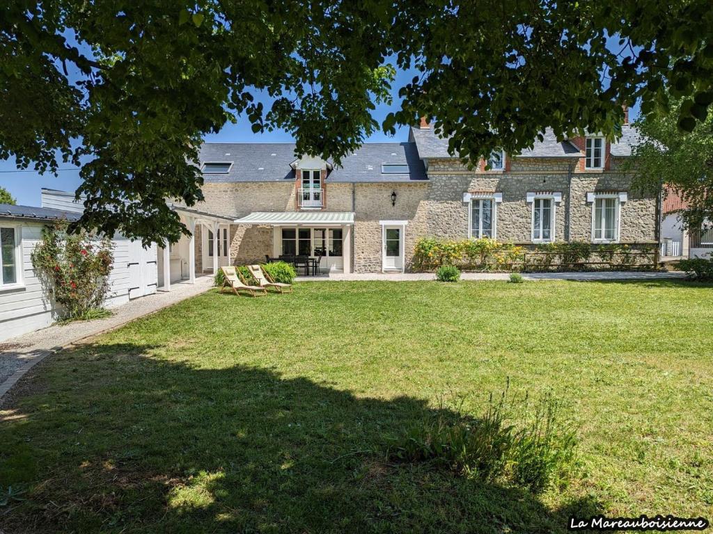 una grande casa in mattoni con un grande cortile di Séjour de charme à Mareau-aux-Bois : parc, home cinéma, billard, tennis et télétravail en fibre ultra-rapide - FR-1-590-279 a Mareau-aux-Bois