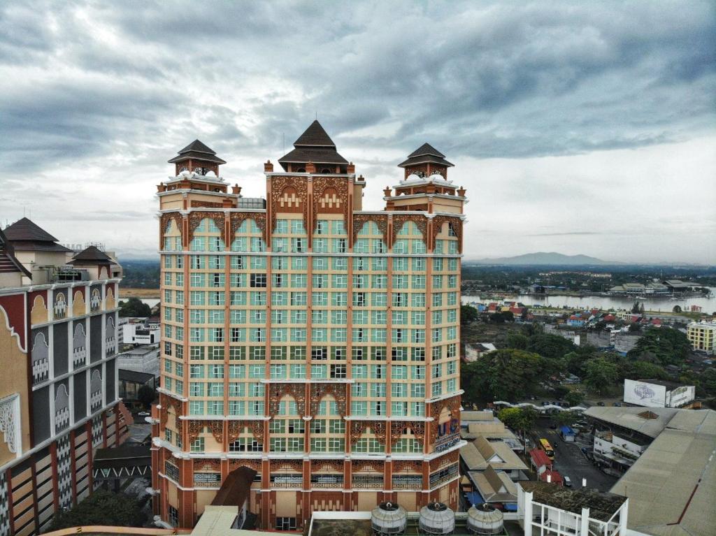 Un grand bâtiment avec deux tours en haut dans l'établissement Paya Bunga Hotel, à Kuala Terengganu