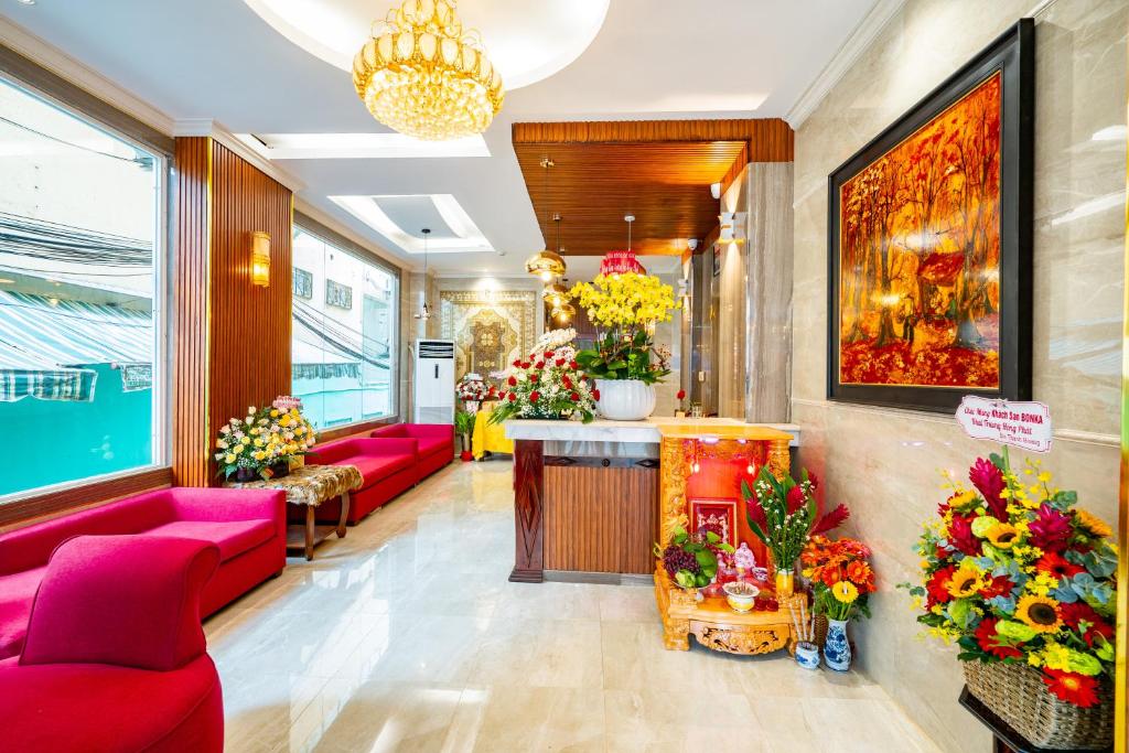eine Lobby mit rosa Sofas und Blumen in einem Laden in der Unterkunft Bonka Hotel Luxury Quận 5 HCM in Ho-Chi-Minh-Stadt