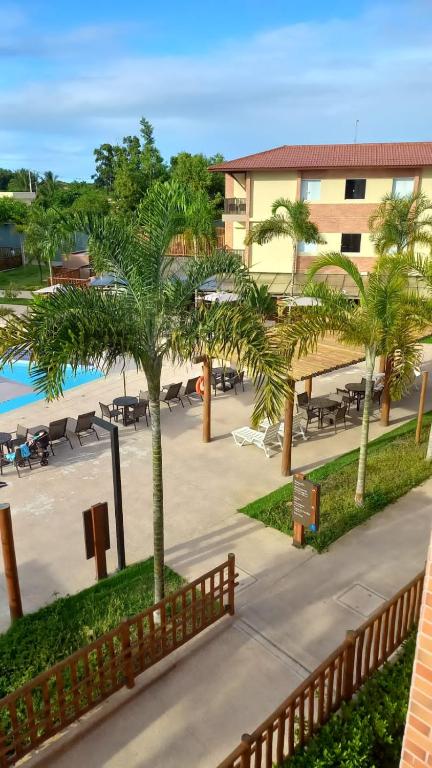 Coroa VermelhaにあるOndas Praia Resortのプールとヤシの木があるリゾートの景色を望めます。