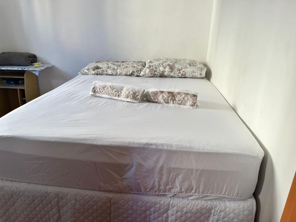 ein Bett mit zwei Kissen darüber in der Unterkunft Flat com boa localização in Palmas