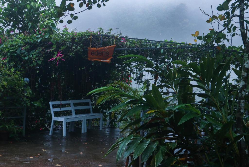 a bench in the rain with a sign that says gets at Edens Munnar in Munnar