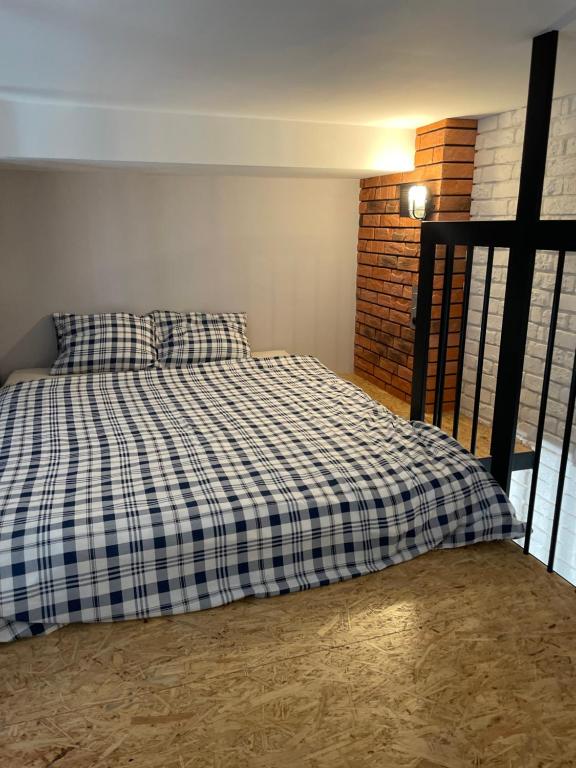 a bed with a checkered blanket in a room at Apartament Hania in Tykocin