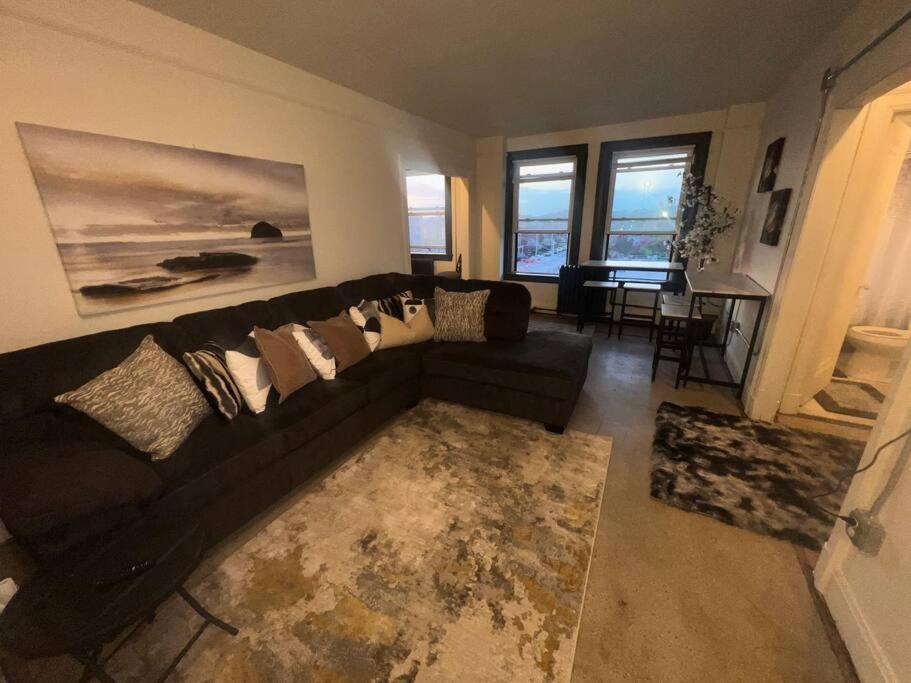 ein Wohnzimmer mit einem schwarzen Sofa und einem Tisch in der Unterkunft 1 Bedroom Apartment Downtown in Detroit