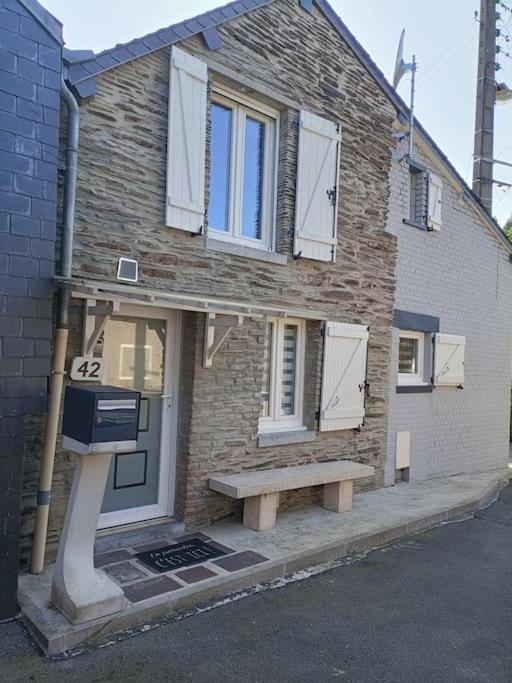 une maison en briques avec un banc devant elle dans l'établissement La Girouette, à Fumay