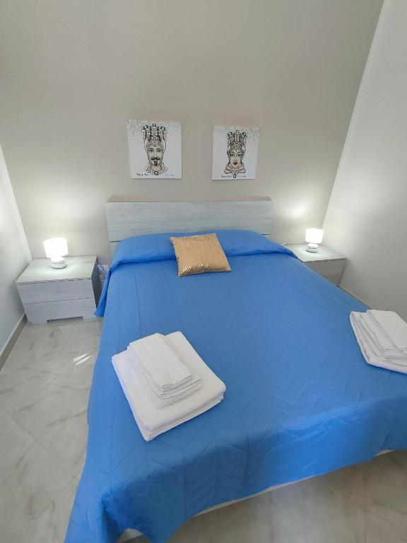 a bedroom with a blue bed with towels on it at Casa Vacanze l' angolo dei Mori in Termini Imerese