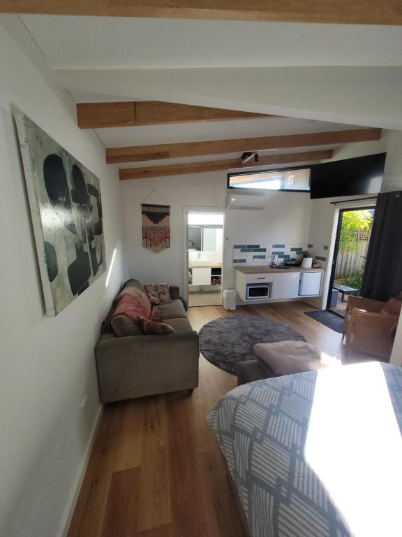 a living room with a couch and a bed in it at Bayside Bungalow in Cheltenham