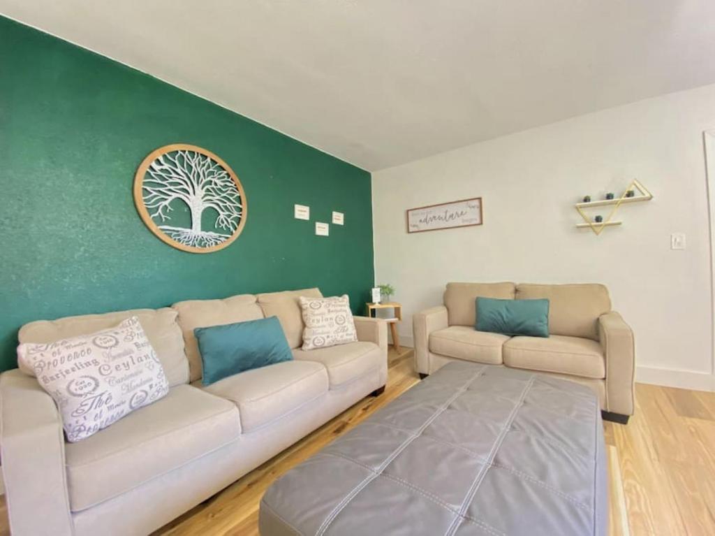 a living room with two couches and a green wall at Lively Home near Downtown, stadium, Wynwood in Miami
