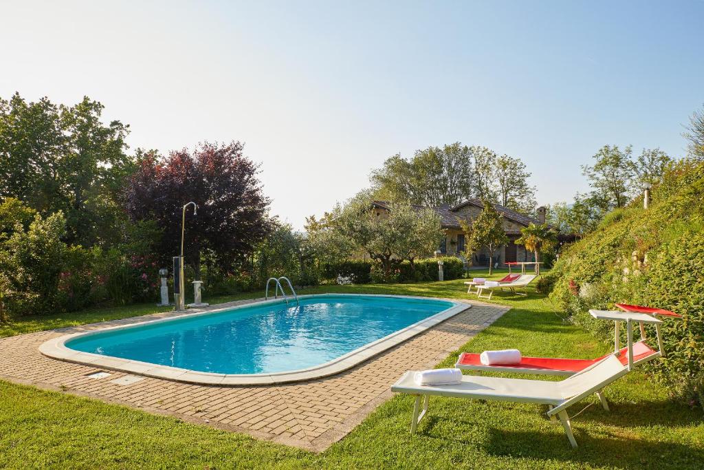 einen Pool in einem Garten mit zwei Liegestühlen in der Unterkunft Villa Belveder - Piscina esclusiva, Parco e Panorama in Castelraimondo