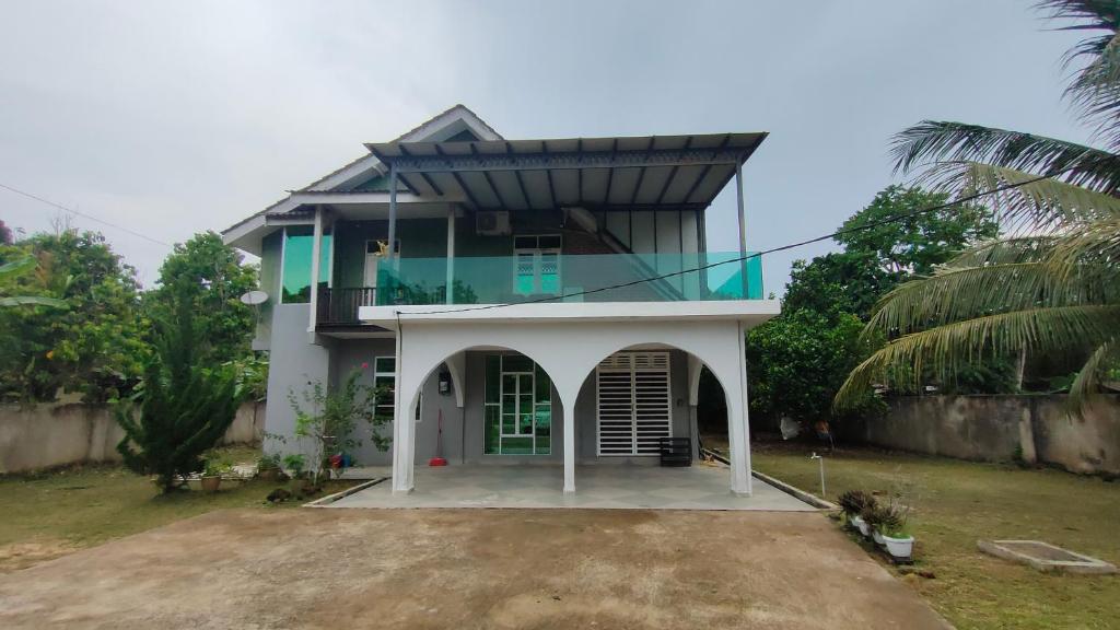 a house with a balcony on top of it at Kak Nor Villa in Kuala Terengganu