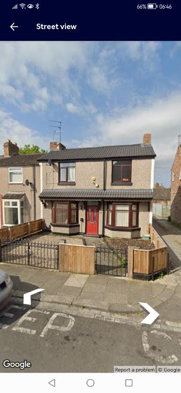 a brick house with a red door on a street at John Street in Shildon