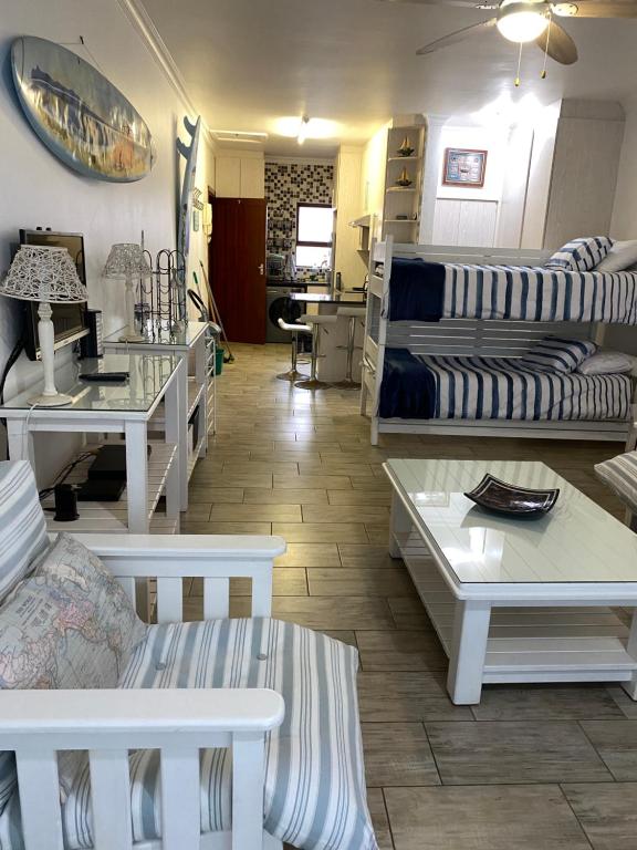 uma sala de estar com mesas brancas e sofás em Flip-Flops em Jeffreys Bay