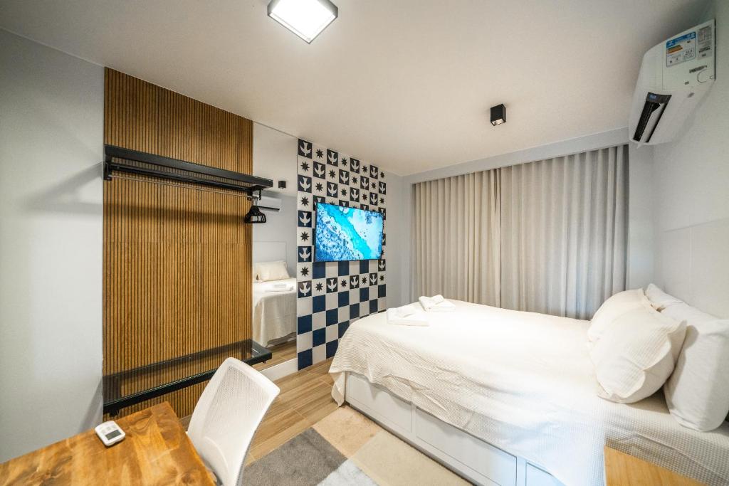 a bedroom with a white bed and a table and chair at Studio247 Experience by Haven in Brasilia