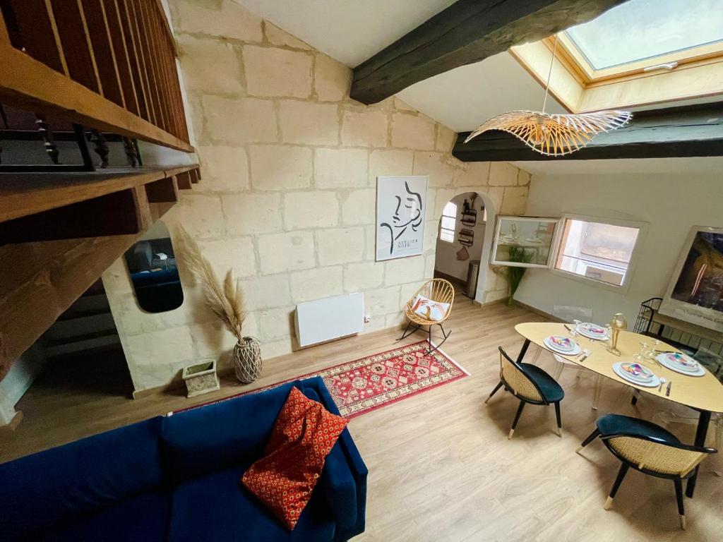 ein Wohnzimmer mit einem blauen Sofa und einem Tisch in der Unterkunft Duplex de charme 80m2 au coeur d'Arles, 2 chambres in Arles