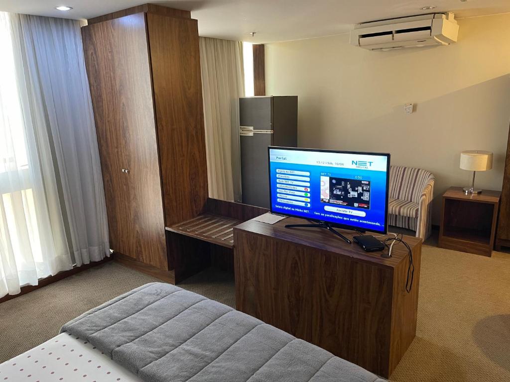 a room with a television on a table with a bed at PROMOÇÃO EXECUTIVA COM BANHEIRA E FLATS SEM BANHEIRA- Melhor Hotel De Taguatinga in Taguatinga