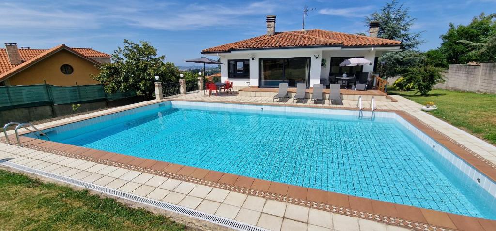 uma piscina em frente a uma casa em El Pastizal de Gijón con Finca, BBQ, FKK y Piscina Privada em La Pedrera