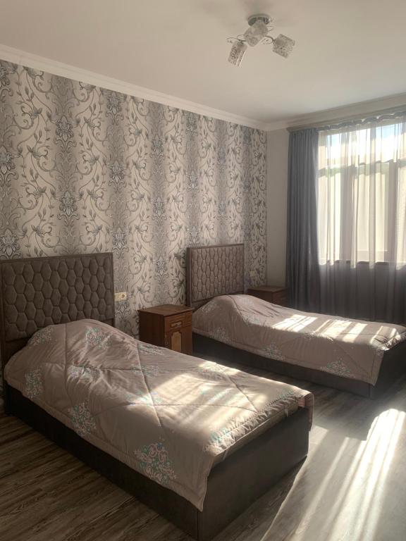 a hotel room with two beds and a window at Ksenya B&B in Tatʼev