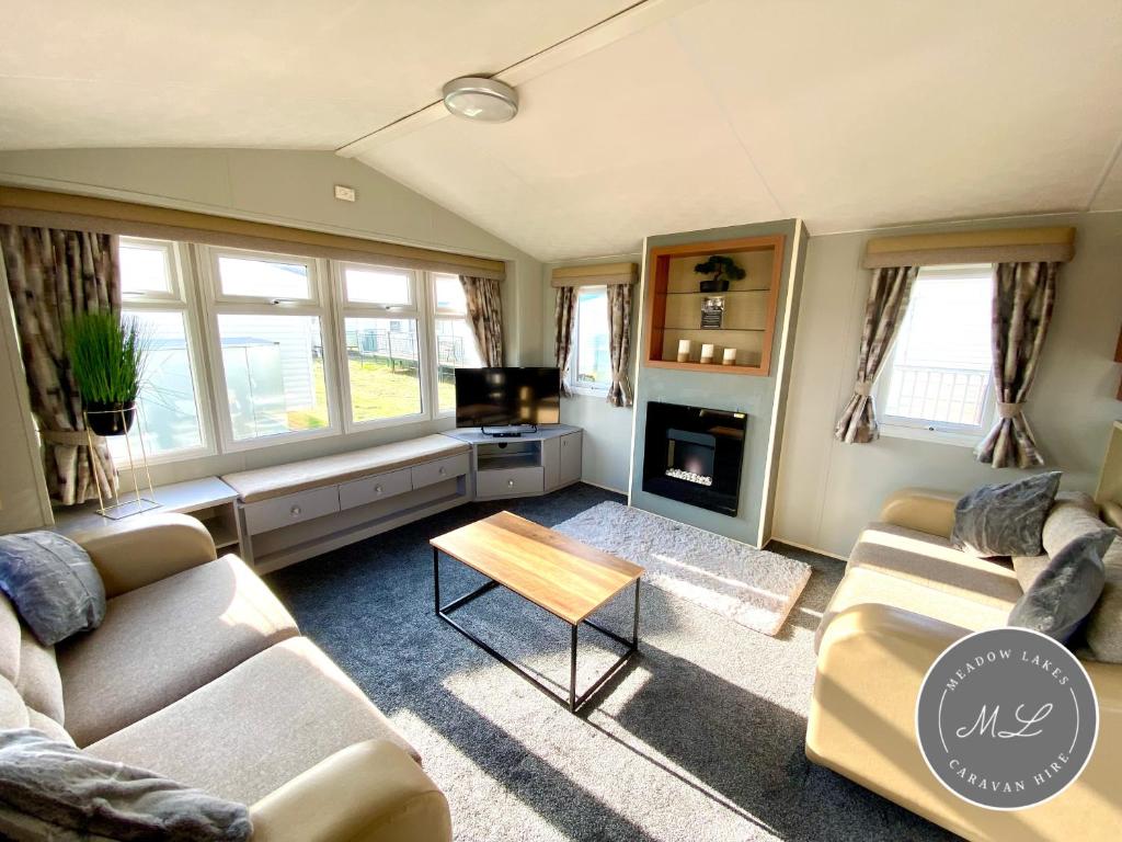 sala de estar con 2 sofás y chimenea en Coral Beach - Ingoldmells - Row 89 Van 1, en Ingoldmells