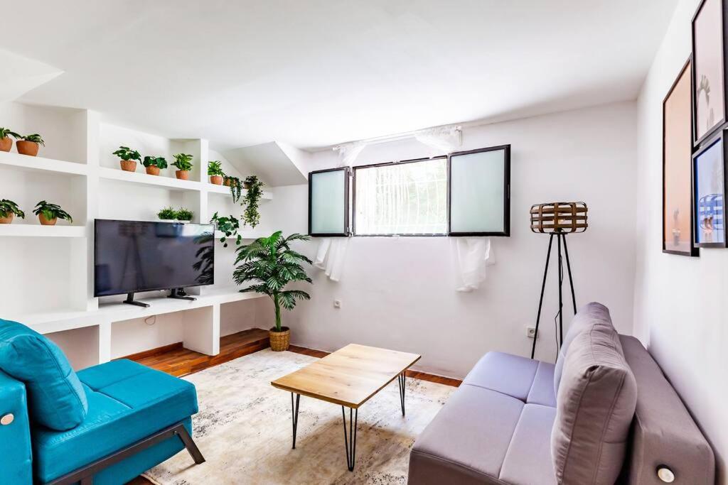 uma sala de estar com um sofá e uma televisão em Triplex on the beach - Hayarkon 30 em Tel Aviv