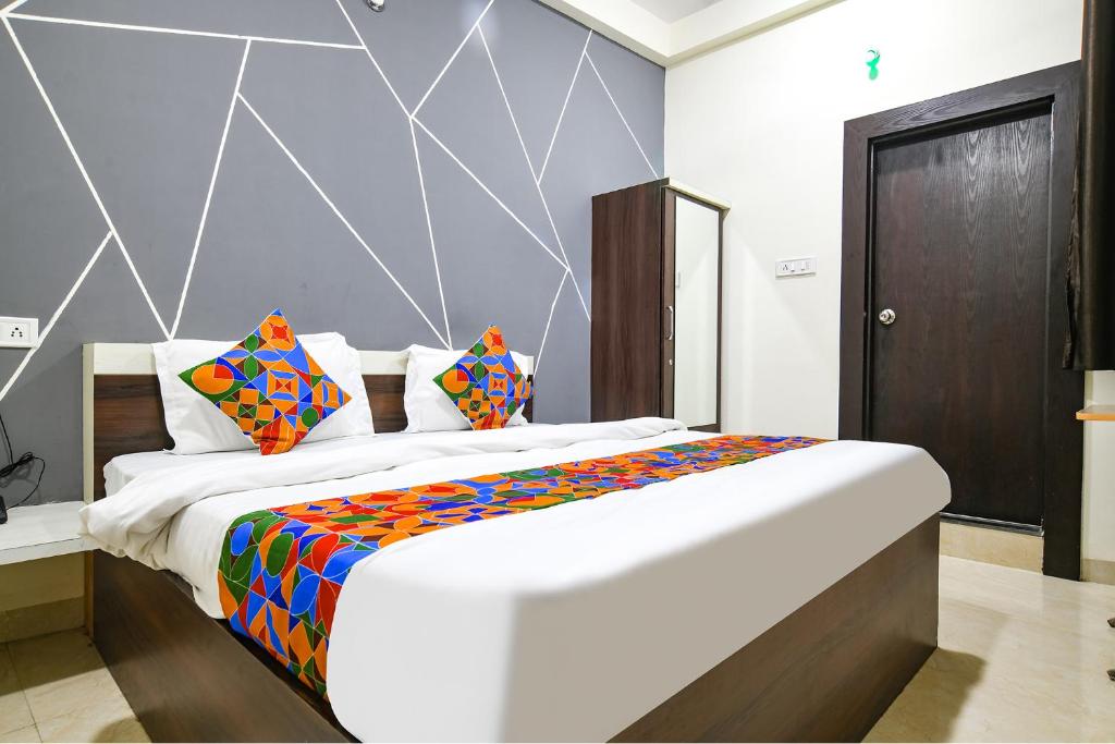 a bedroom with a large bed with colorful pillows at FabExpress SP7 in Indore