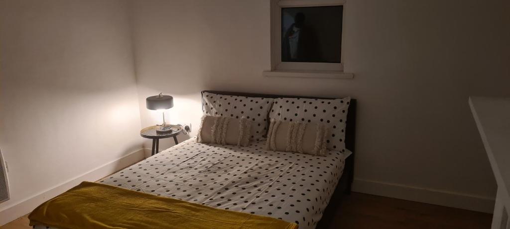 um pequeno quarto com uma cama com lençóis de bolinhas em BELLACASA GUESTHOUSE em Nottingham
