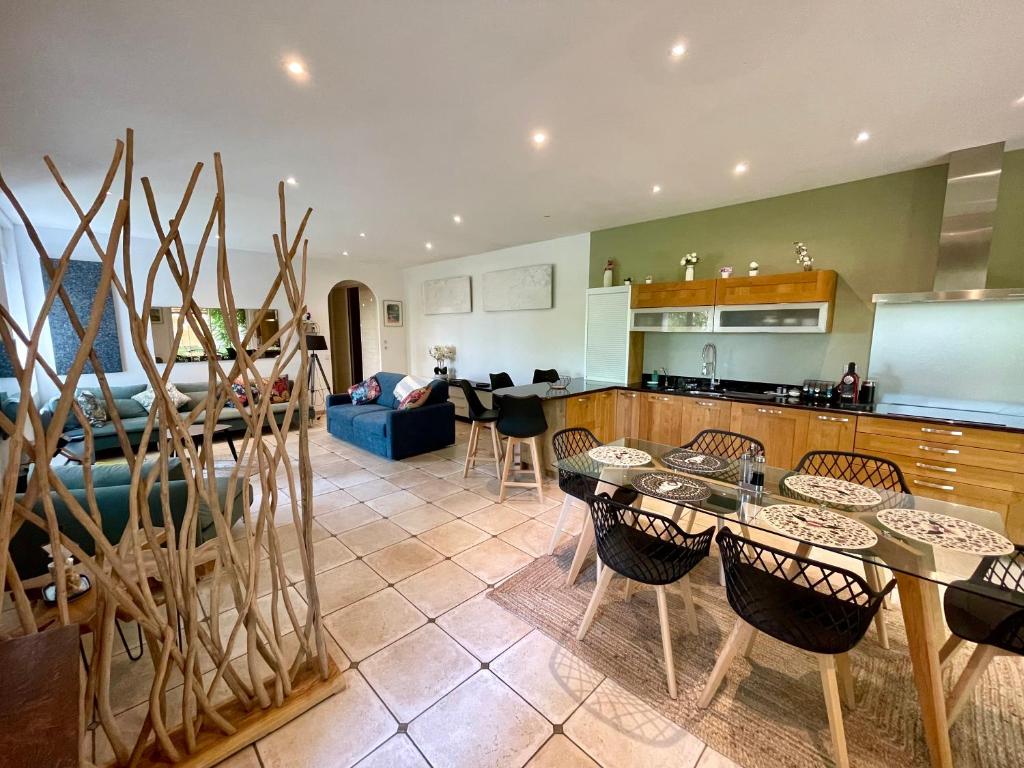 eine Küche und ein Wohnzimmer mit Tischen und Stühlen in der Unterkunft L'annexe du domaine de brisset in Montélimar