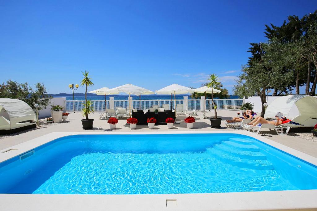 a swimming pool with a view of the ocean at Villa Triana-Adults Only in Zadar