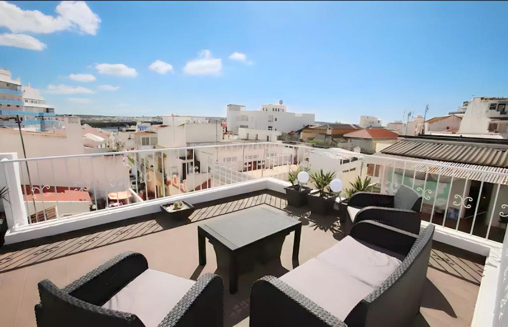 een balkon met stoelen en een tafel op een dak bij Isa SkyHouse Algarve in Portimão