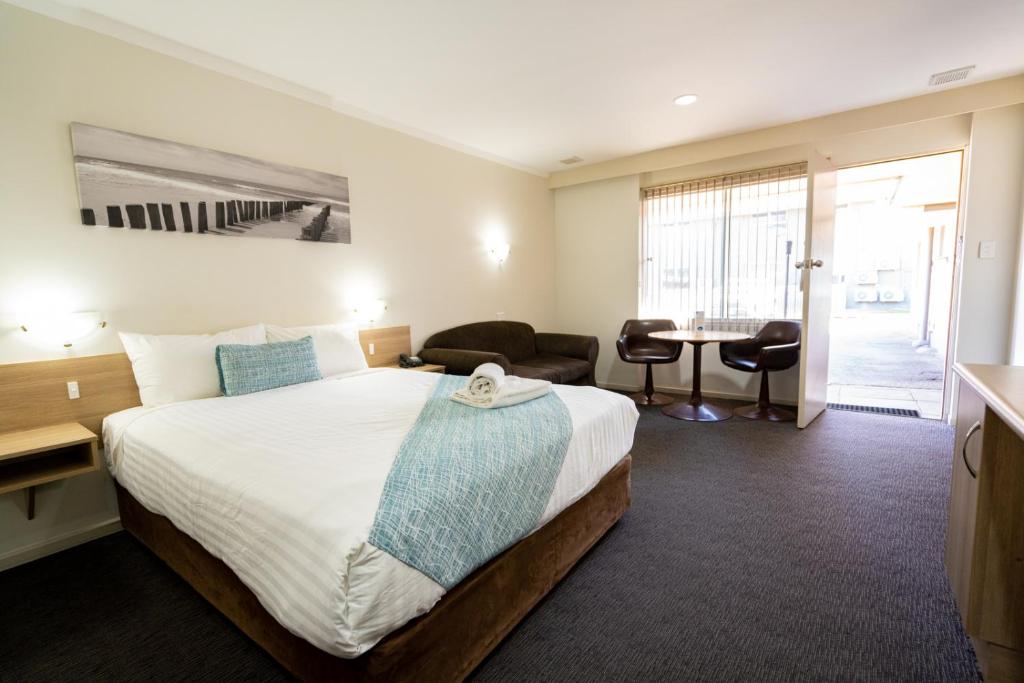 ein Hotelzimmer mit einem großen Bett und einem Schreibtisch in der Unterkunft Hospitality Esperance SureStay Collection by Best Western in Esperance