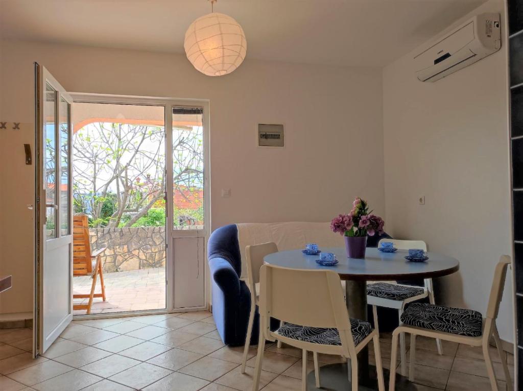a kitchen and dining room with a table and chairs at Apartment Rose in Krk