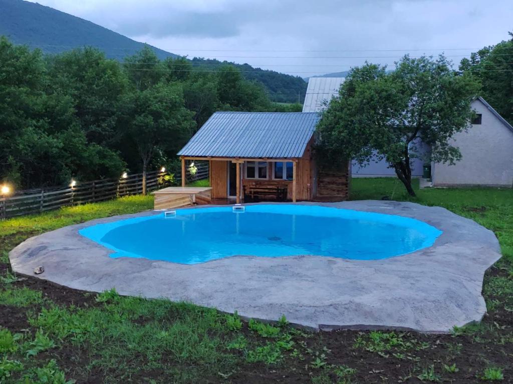una pequeña piscina frente a una casita en Vila Bella en Lagos de Plitvice