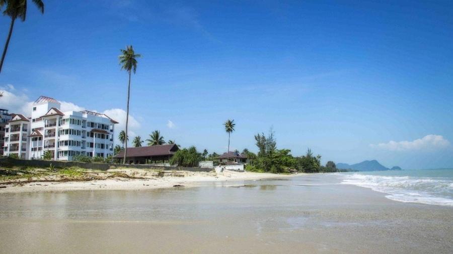 vista su una spiaggia con un hotel e palme di Khanom Beach Residence 1-bedroom Mountain & Sea View a Khanom