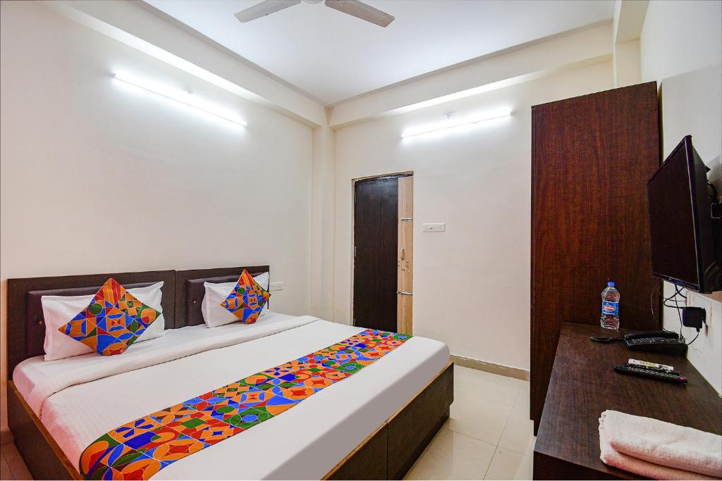 a bedroom with a large bed and a television at FabExpress SR in Bārang