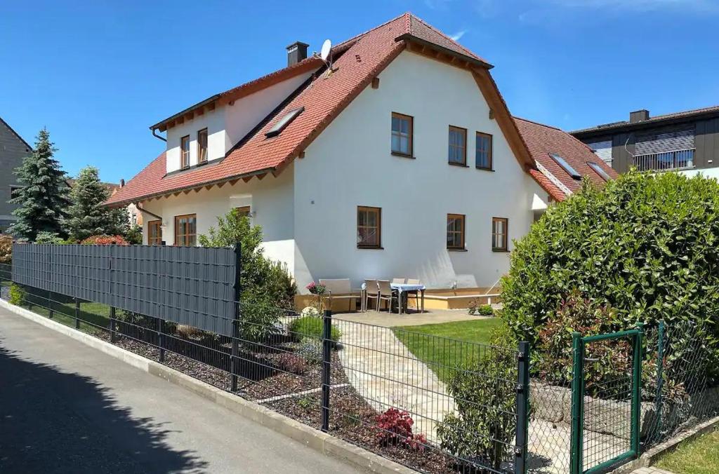 a white house with a red roof at Ferienwohnung Am Berg in Pinzberg