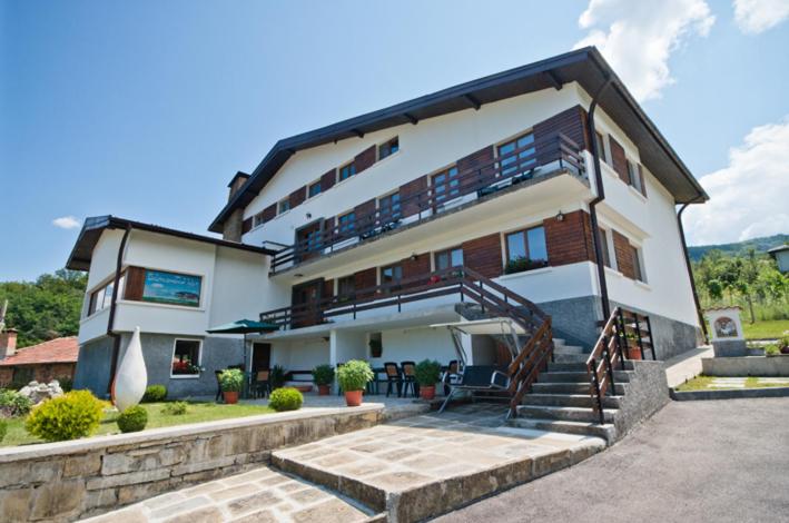a large building with a staircase in front of it at Guest House Balkanski Kat in Gabrovo
